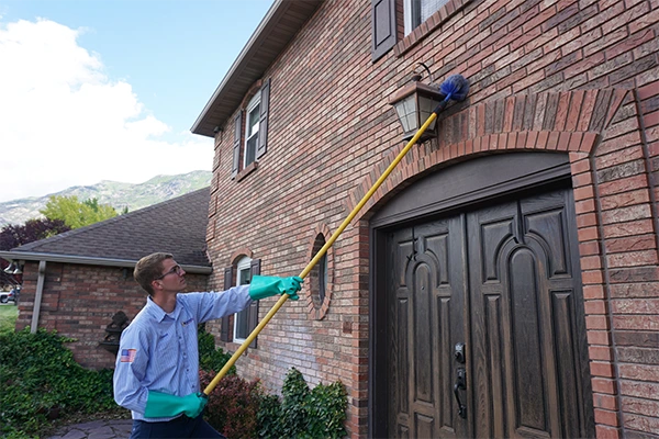 Guardian Pest Control technician removing a wasp nest at a customer’s Utah home.