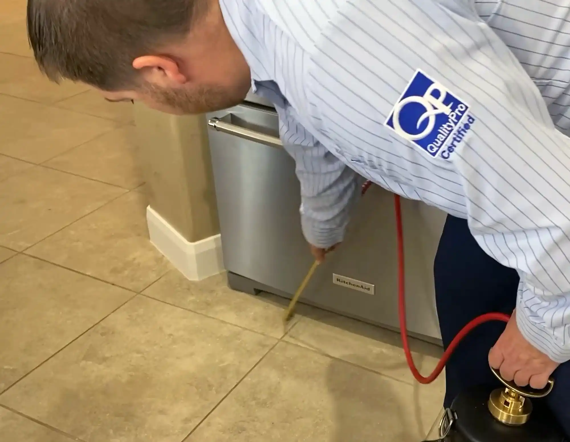 Guardian Pest Control technician applying ant control treatment in a customer’s kitchen in Utah
