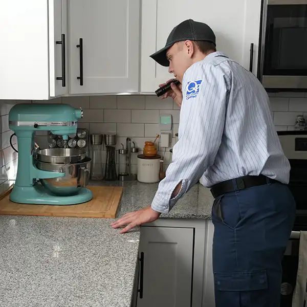 Guardian Pest Control technician inspecting a customer’s kitchen for pest problems in Utah