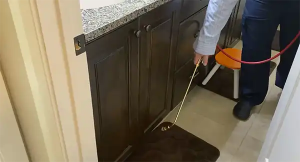 Technician treating ants indoors with professional pest control products in Salt Lake City, Utah.